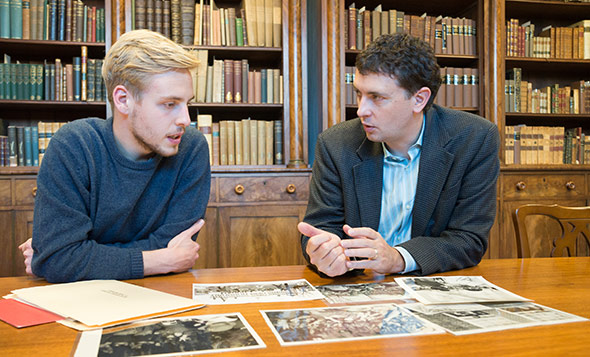 Max Wieland ’17, left, and Associate Professor of History Edward Miller discuss photos for the Dartmouth Vietnam Project. (Photo by Eli Burakian ’00)